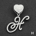 Close-up of iced out silver letter H pendant with heart bail on black background - Letter H / Silver