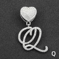 Close-up of heart-shaped pendant with iced-out cursive letter Q and micro-pave crystals - Letter Q / Silver