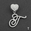 Close-up of sparkling iced out letter T pendant with heart clasp on black texture - Letter T / Silver