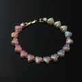 Detail of gold heart link bracelet with rainbow scale texture and iridescent stones - Gold