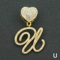 Macro shot of iced-out letter U pendant with golden heart buckle and paved crystals - Letter U / Gold
