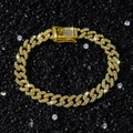 Dettaglio macro della collana a catena cubana dorata con strass su sfondo nero minerale - Bracciale (18cm) / Oro