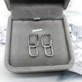 Macro detail of silver S925 oval double hoop earrings displayed in a grey velvet jewelry box - Full 925 Sterling Silver / White Gold