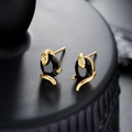 Gros plan de boucles d'oreilles serpent dorées avec une pierre noire facettée sur socle - Serpent de couleur dorée avec zircon noir