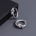 Boucles d'oreilles nœuds en argent sterling S925 poli sur un fond texturé sombre - Boucle d'Oreille Nœud