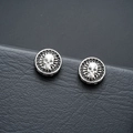 Macro shot of silver skull magnetic earrings with black zircons on leather texture - Punk Skull (X811-F) / One Pair