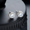 Primo piano di orecchini a lobo halo scintillanti con pavé di diamanti su fondo nero - Argento