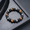 Nahaufnahme von Tigerauge-, Obsidian- und Hämatitperlen auf einem dunklen Holztablett - Tigerauge-Stil (S824-A) / 10mm