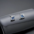 Macro-opname van zilveren magnetische oorbellen met lavatextuur en blauwe fonkelende glitters - Oorknopjes / Stralend Blauw