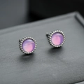 Macro view of round purple stone stud earrings with milgrain silver edge detail - Purple