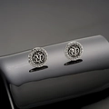 Detalle macro de aretes vintage plateados con símbolos de runas y motivos de grecas - Pendientes de Botón de Runa / Plata Antigua