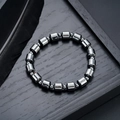 Macro de perles d'hématite gris foncé avec éclat métallique sur plateau en bois - Style Cylindre Poli (S733-B)