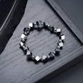 Macro detail of black hematite square beads and silver spacer beads on a textured surface - Black and Silver Alternating Style (S733-E)