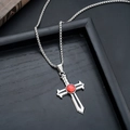 Close-up of a silver sword cross pendant with a red gemstone on a bead chain necklace - Flame Holy Cross (L8888-O)