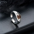Vue macro d'une bague Oeil d'Horus argentée avec incrustation de pierre brune polie - Style Oeil d'Horus (J1301-A)