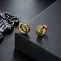 Detailansicht der goldenen keltischen Huggie-Ohrringe mit fein geflochtener Reliefstruktur - Antikgold