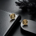 Detaillierte Ansicht goldener Vintage-Ohrstecker mit Fu-Relief auf schwarzem Lederständer - Gold