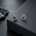 Close-up of gothic star stud earrings with dark gem in vintage silver finish - Green