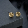 Macro shot of vintage gold-tone round stud earrings featuring intricate dragon relief patterns - Antique Gold Pair