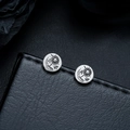 Macro shot of vintage round earrings with sun and moon engravings on black leather surface - Eagle Sun Style / Antique Silver