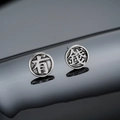 Macro detail of vintage matte silver studs with Fu characters on a reflective surface - Rich Stud Earrings (Silver) / 8mm