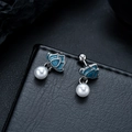 Macro shot of silver lotus stud earrings with blue enamel petals and round white pearls - X763-B (Lotus Stud) / Blue (Single Piece)
