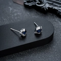 Dettaglio di orecchini a lobo argento con pietre blu a goccia su sfondo nero materico - Stile Argento Zirconia Blu (X561-C)
