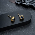 Detailed macro view of golden eye stud earrings featuring a blue oval gemstone setting - Gold Blue Zirconia Style (X561-F)