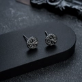 Primer plano de pendientes redondos negros retro con detalle de cruz en relieve gótico - Negro de Humo