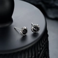 Dettaglio di orecchini a lobo in argento con zircone nero e base con texture - Nero