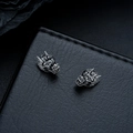 Detailed macro view of dark metal dragon head stud earrings on black leather surface - Clip-on Earrings / Gunmetal