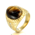 Macro detail of gold-plated signet ring with oval tiger eye stone and zircons - Gold Tiger's Eye