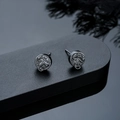 Detailed close-up of retro scorpion relief earrings with dark metallic finish and texture - Stud Earrings / Gunmetal
