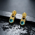 Macro shot of gold zipper head stud earrings with blue zircon and engraved LOOK details - Gold