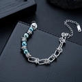 Detail of polished stainless steel chain bracelet with blue metallic beads on leather - Blue Beaded Style