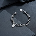 Silbernes Panzerarmband mit Good Luck Anhänger auf dunklem Steinhintergrund - Glücksarmband (S541-A)
