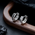 Dettaglio di orecchini a cerchio in argento con zirconi bianchi e neri e trafori eleganti - Argento con Strass Nero