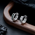 Dettaglio macro di orecchini a cerchio in argento con zirconi verdi e motivi a stella - Argento con zircone verde