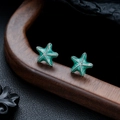 Dettaglio degli orecchini a stella marina verde menta su supporto in legno - Verde
