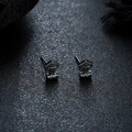 Vista macro de pendientes estilo vikingo con intrincados patrones de volutas grabados - Color gunmetal