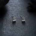 Detalle de los pendientes martillo vikingo plateados sobre una superficie de piedra negra - Plateado