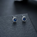 Dettaglio macro di orecchini a serpente in argento con gemma blu e piccoli occhi verdi - Argento Strass Blu