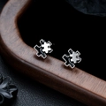 Close-up of puzzle-shaped stud earrings in black enamel and silver-tone finish - Black Silver