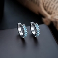 Macro shot of silver hinged hoop earrings with five channel-set light blue gemstones - Silver Frame + Sea Blue Zirconia (1 Pair)