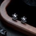 Detail shot of irregular puzzle stud earring with black enamel and polished metal edges - Black Gun Black