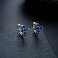 Details von silbernen Kreuz-Ohrringen mit dunkelblauen Zirkonia-Steinen besetzt - Silber-Blauer Strass