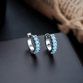 Macro view of silver hoop earrings with inset sky blue gemstones and polished finish - Silver Frame + Sky Blue Zirconia (1 Pair)