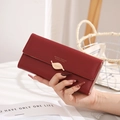 Détail du portefeuille long en cuir rouge avec boucle métallique en forme de feuille - Bordeaux