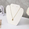 Elegant gold necklace with twisted drop pendant and purple gemstone on a white display - Small Apple Style / White Leather