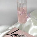 Detailed view of pink ribbed champagne flute featuring glass butterfly accents - Tall Striped / Pink